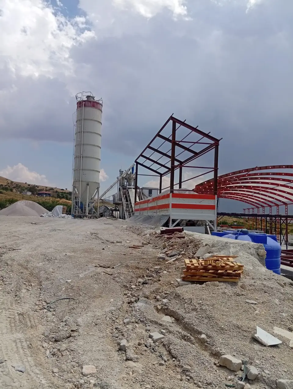 Beton santrali yanında yükselen çelik karkas ve hangar kemerleri